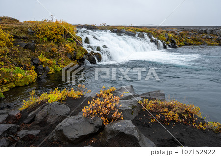 Grafarlandsfoss falls amidst autumn vegetation and black lava fields, Iceland. Grafarlandsfoss falls amidst autumn vegetation and black lava fields, Iceland. 107152922