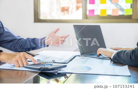 hand use calculator, businesswomen and businessmen team meeting to plan strategies to increase business income 107153241