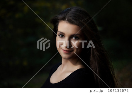 Portrait of attractive long haired young woman posing outdoors. 107153672