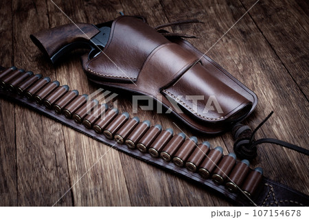 Old west leather gun belt with ammnunitions and revolver in holster Old west leather gun belt with ammnunitions and revolver in holster 107154678