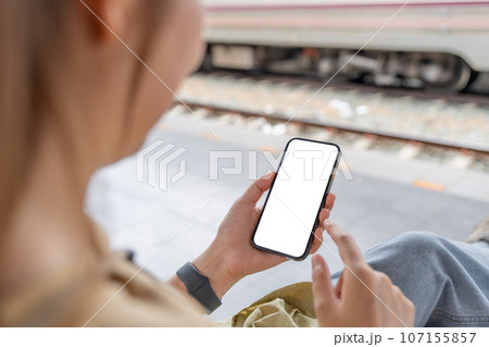 Asian woman using smartphone while waiting train Asian woman using smartphone while waiting train 107155857