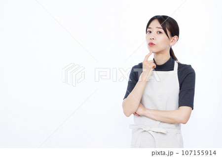 白い背景の前で真剣に悩んでいる30代の主婦 107155914