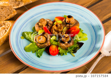 Baked champignons with spinach, lettuce, tomatoes, celery Baked champignons with spinach, lettuce, tomatoes, celery 107157584