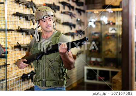 Man in army uniform with weapon in military market 107157682