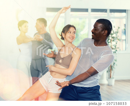 Smiling African American man supporting young woman in dance Smiling African American man supporting young woman in dance 107158033