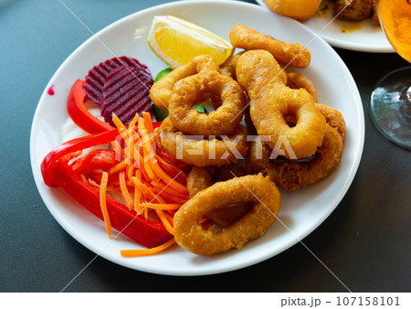 Rings of squid in batter with sliced vegetables.Snack to beer Rings of squid in batter with sliced vegetables.Snack to beer 107158101