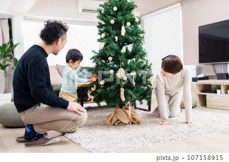 クリスマスツリーの飾り付けをする家族 クリスマスツリーの飾り付けをする家族 107158915
