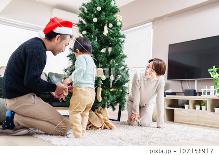 クリスマスツリーの飾り付けをする家族 クリスマスツリーの飾り付けをする家族 107158917