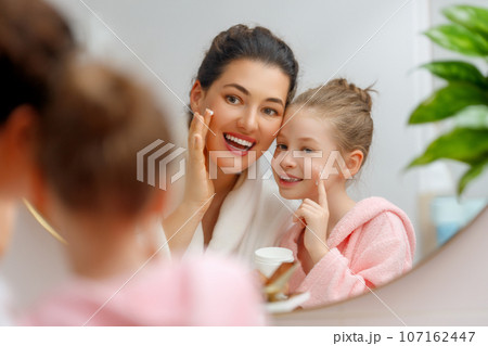Mother and daughter caring for skin 107162447