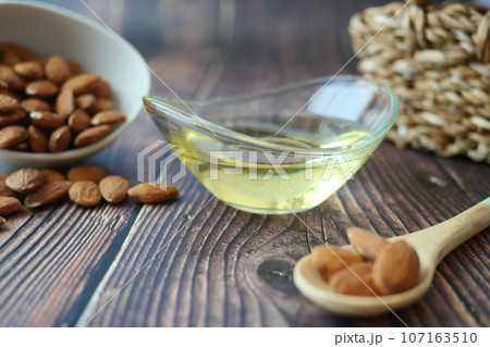 almond oils and fresh nuts on table  107163510