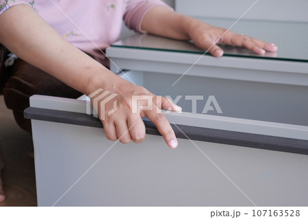 women hand open drawer wooden in cabinet 107163528