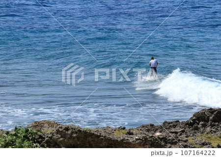 与那国島ウブドゥマイ浜でサーファーが波の上を走る光景 107164222