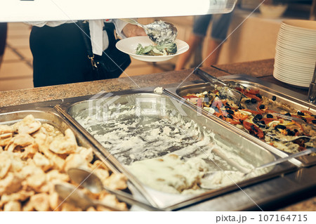 The kitchen of the cafeteria is a buffet with food at school or college. A showcase with self-service food. High quality photo The kitchen of the cafeteria is a buffet with food at school or college. A showcase with self-service food. High quality photo 107164715