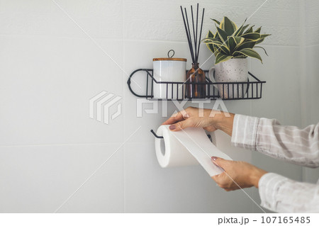 Close-up of a man's hand using white toilet paper. Close-up of a man's hand using white toilet paper. 107165485