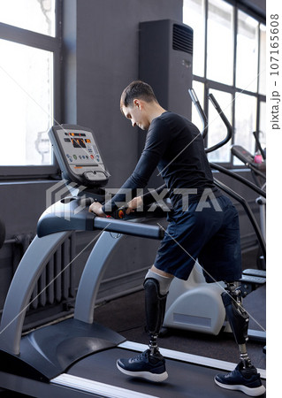 ambitious man concentrated on walking on treadmill 107165608