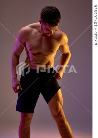 young muscular man in black sportswear has painful feelings in leg. 107165826
