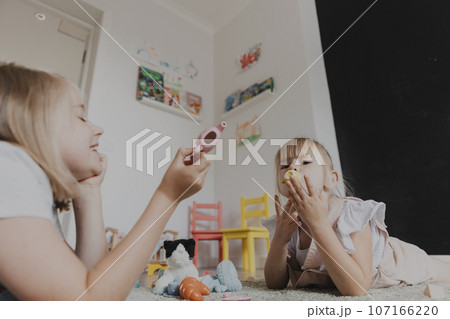 Children playing with toy play tea set on the floor at home or kindergarten 107166220