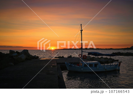 Beautiful colourful sunset on the beach with the sea and waves. A concept for travel, holidays and summer holidays by the sea. Greece - Corfu island - Agios Georgios. 107166543