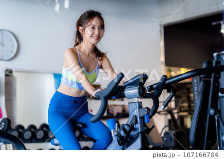 スポーツジムでトレーニングする若い女性 107166784