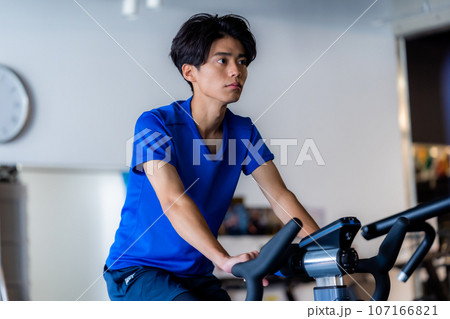 スポーツジムでトレーニングする若い男性 スポーツジムでトレーニングする若い男性 107166821