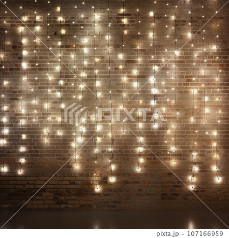Minimalist white brick wall adorned with shimmering Christmas lights, perfect for background. 107166959
