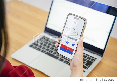 スマホで投資をする女性 107167005