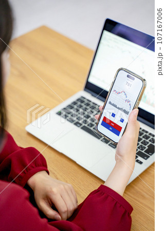 スマホで投資をする女性 スマホで投資をする女性 107167006