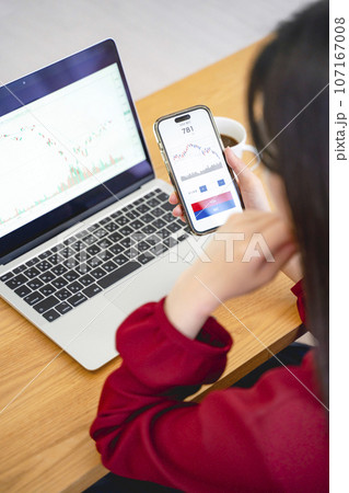 スマホで投資をする女性 スマホで投資をする女性 107167008