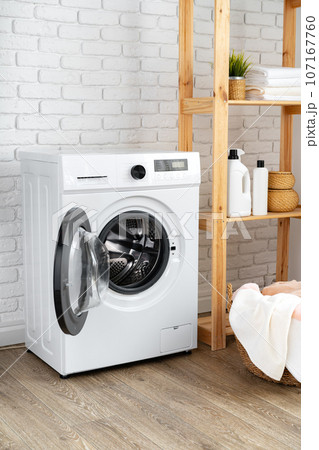 Laundry room with washing machine and basket with laundry Laundry room with washing machine and basket with laundry 107167760
