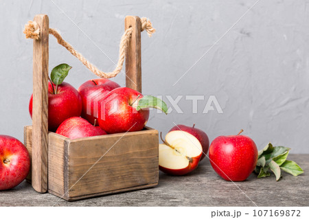 Ripe red apples in wooden box. On a white wooden background 107169872