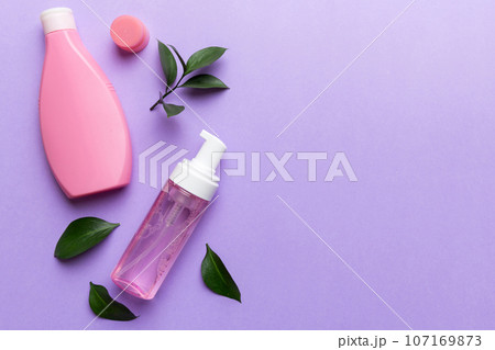 Organic cosmetic products with green leaves on color background. Copy space, flat lay 107169873
