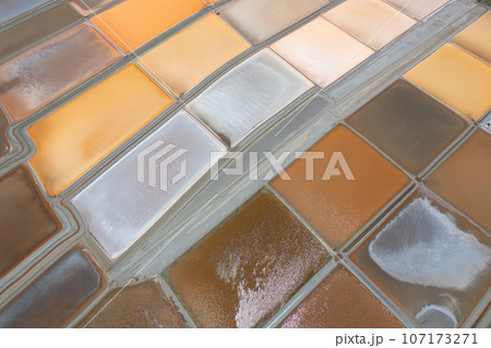 Aerial view of natural sea salt ponds, lake or sea. Farm field outdoor in traditional industry in Thailand. Asia culture. Agriculture irrigation. River reflection. 107173271