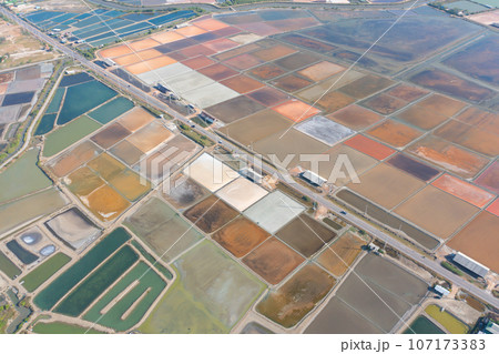 Aerial view of natural sea salt ponds, lake or sea. Farm field outdoor in traditional industry in Thailand. Asia culture. Agriculture irrigation. River reflection. Aerial view of natural sea salt ponds, lake or sea. Farm field outdoor in traditional industry in Thailand. Asia culture. Agriculture irrigation. River reflection. 107173383