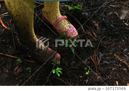 森の泥にまみれた女の子の足元 107173569