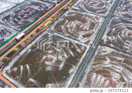 Aerial view of natural sea salt ponds, lake or sea. Farm field outdoor in traditional industry in Thailand. Asia culture. Agriculture irrigation. River reflection. 107174121