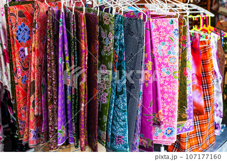 Multicolored womens shawls on hangers sale at street market Multicolored womens shawls on hangers sale at street market 107177160