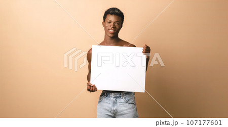 Smiling black young male model with blank poster 107177601