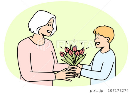 Smiling boy greeting granny with flowers 107178274