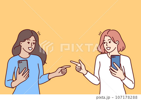 Women with mobile phones point fingers at each other, rejoicing at first meeting 107178288