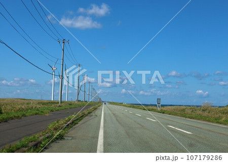 北海道最北の地、オホーツクを望む牧草地の一本道、その名は猿払村道エサヌカ線、夏の空に映えるツーリング 107179286