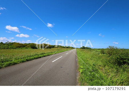 北海道最北の地、オホーツクを望む牧草地の一本道、その名は猿払村道エサヌカ線、夏の空に映えるツーリング 107179291