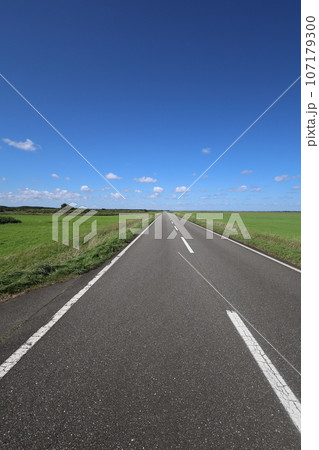 北海道最北の地、オホーツクを望む牧草地の一本道、その名は猿払村道エサヌカ線、夏の空に映えるツーリング 107179300