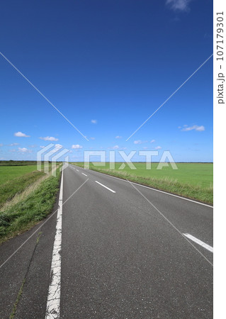 北海道最北の地、オホーツクを望む牧草地の一本道、その名は猿払村道エサヌカ線、夏の空に映えるツーリング 107179301