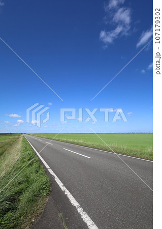 北海道最北の地、オホーツクを望む牧草地の一本道、その名は猿払村道エサヌカ線、夏の空に映えるツーリング 107179302