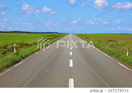 北海道最北の地、オホーツクを望む牧草地の一本道、その名は猿払村道エサヌカ線、夏の空に映えるツーリング 107179333