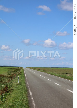 北海道最北の地、オホーツクを望む牧草地の一本道、その名は猿払村道エサヌカ線、夏の空に映えるツーリング 107179335