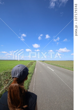 北海道最北の地、オホーツクを望む牧草地の一本道、その名は猿払村道エサヌカ線、夏の空に映えるツーリング 107179348