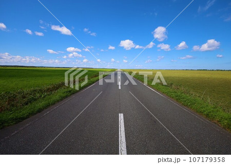 北海道最北の地、オホーツクを望む牧草地の一本道、その名は猿払村道エサヌカ線、夏の空に映えるツーリング 107179358