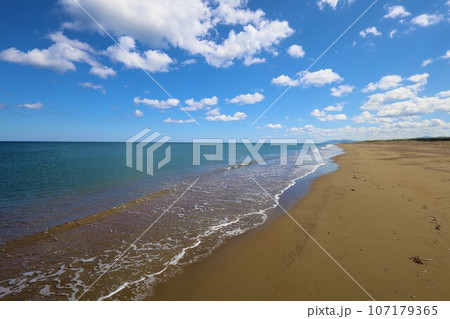 北海道最北の地、オホーツクを望む牧草地の一本道、その名は猿払村道エサヌカ線、夏の空に映えるツーリング 107179365