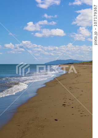 北海道最北の地、オホーツクを望む牧草地の一本道、その名は猿払村道エサヌカ線、夏の空に映えるツーリング 107179367